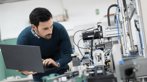 Engineer reviewing manufacturing equipment during factory capability review